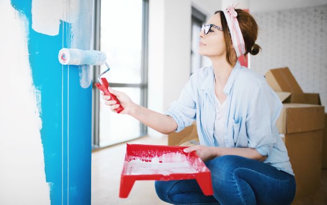 Woman painting wall in home